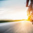 motorcyclist riding on highway towards the sun